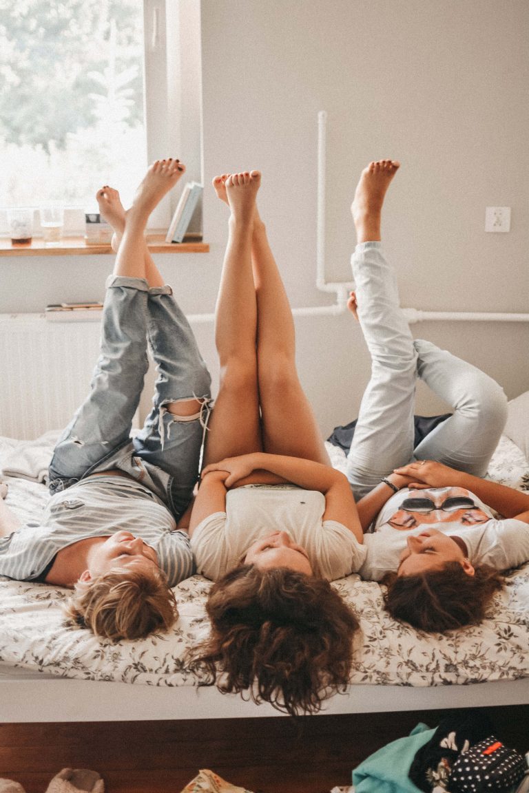 three people laying on a bed with their legs in the air at Summerall riverview rentals